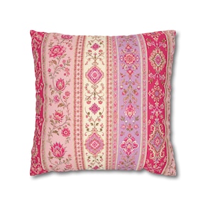 May include: A square throw pillow featuring a vertical striped pattern in shades of hot pink, light pink, lavender, and cream. The design includes intricate floral motifs, scrolling vines, and geometric diamond shapes across the fabric surface.