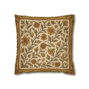 Pode incluir: Almofada decorativa quadrada com um padrão floral. A almofada apresenta um fundo creme com um desenho repetido de flores e folhas castanhas e amarelas. A borda é um amarelo mais escuro com um padrão repetido.