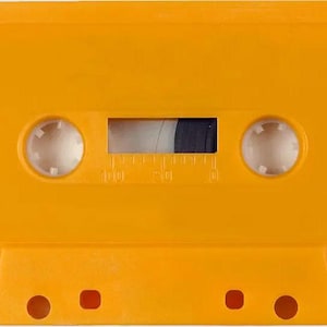 May include: A close-up of a bright yellow cassette tape. The tape has two circular holes on the top and three rectangular holes on the bottom. The tape window reveals the black and white tape inside.