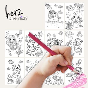 Puede incluir: Una colecci&oacute;n de ocho p&aacute;ginas para colorear con tem&aacute;tica de sirenas con varios dise&ntilde;os, incluyendo sirenas, peces y plantas submarinas. Una mano est&aacute; coloreando una de las p&aacute;ginas con un l&aacute;piz de color rosa. La esquina superior izquierda tiene el texto "herz & herrlich".