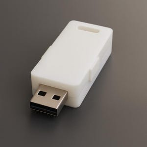 Puede incluir: Una unidad flash USB blanca con un cuerpo rectangular y un conector USB plateado. La unidad tiene una pequeña ranura rectangular en la parte superior. El fondo es de color gris sólido.