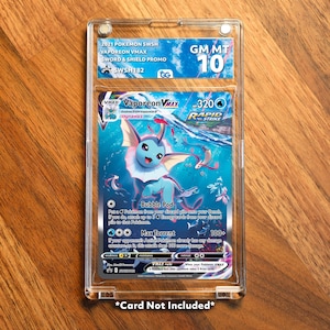 Könnte beinhalten: Eine bewertete Pokémon Vaporeon VMAX-Karte in einer Schutzhülle. Die Karte zeigt ein blaues und weißes Wassertier mit dem Text "Vaporeon VMAX" und "Rapid Strike". Die Hülle hat ein "GM MT 10"-Bewertungslabel und den Text "2021 Pokemon SWSH".