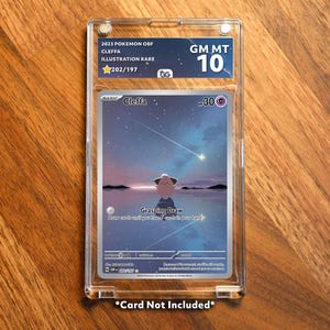 May include: A graded Pokémon card in a clear protective case. The card features Cleffa, with the text "Grasping Draw." The case is labeled "GM MT 10" and "202/197." The card is set against a landscape with a starry sky. The text "Card Not Included" is at the bottom.