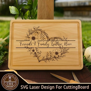 Puede incluir: Tabla de cortar rectangular de madera con un diseño de corazón floral y el texto "Friends & Family Gather Here". La tabla tiene un borde empotrado y está grabada con láser. La parte inferior de la tabla tiene el texto "SVG Laser Design For CuttingBoard".