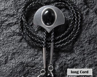 May include: A black bolo tie with a silver-toned metal pendant featuring a large oval black stone. The braided cord is black, and the tie has silver-toned metal tips and matching black stone accents. The cord length is 39.7 inches.
