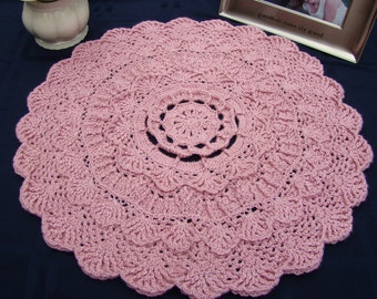 Dusty pink rose textured crocheted doily with scallop edging and three-dimensional design