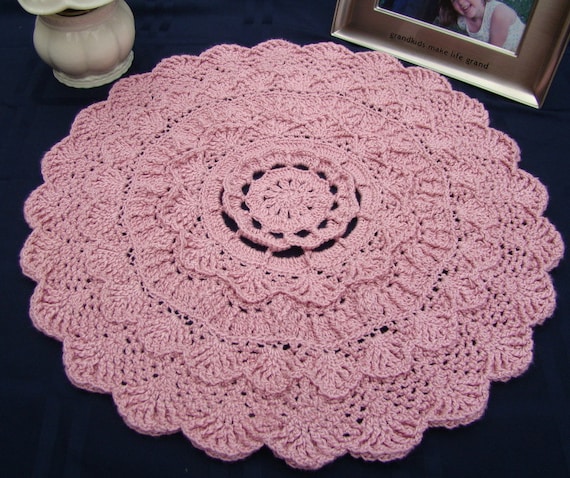 Dusty pink rose textured crocheted doily with scallop edging and three-dimensional design