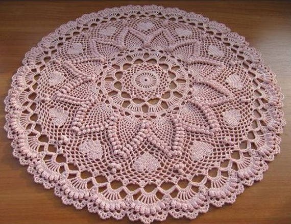 Pink crocheted table topper with pineapple and popcorn stitching