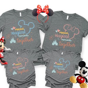 May include: Gray t-shirts with the text "Making Magical Memories Together" in blue and pink, featuring Mickey and Minnie Mouse designs. A Minnie Mouse headband and two Minnie and Mickey Mouse plush toys are also in the image.