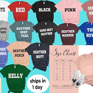 May include: A selection of short-sleeved t-shirts in a range of colours, such as white, red, black, pink, and heather mauve. Each shirt has its colour name printed in bold white text. A size chart and a peach-coloured shirt are also visible.