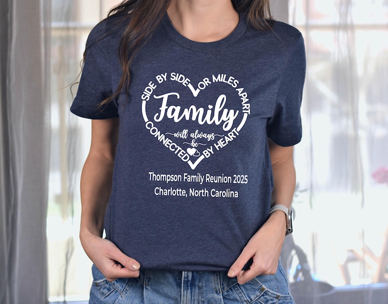 May include: Navy blue t-shirt with a white heart-shaped graphic that reads "Family will always be connected by heart." Below the graphic is "Thompson Family Reunion 2025, Charlotte, North Carolina."