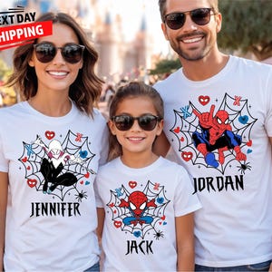 May include: Three people wearing white t-shirts with superhero designs. The shirts feature Spider-Man and Spider-Gwen graphics within a spiderweb design, with names printed below. The image includes the text "NEXT DAY SHIPPING".