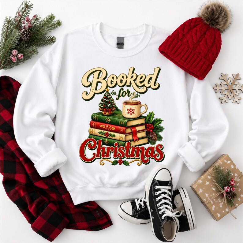A white sweatshirt with a graphic design of books and a mug, surrounded by holiday decorations such as a red knit hat, a red and black plaid shirt, and a pair of black and white sneakers.