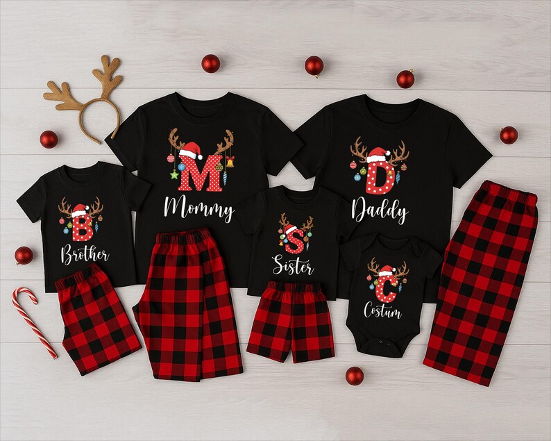 May include: Matching family Christmas pajamas sets in black with red and black plaid bottoms. Each shirt has a letter and the word "Mommy", "Daddy", "Brother", "Sister", and "Costum". The shirts have a reindeer and Santa hat design.