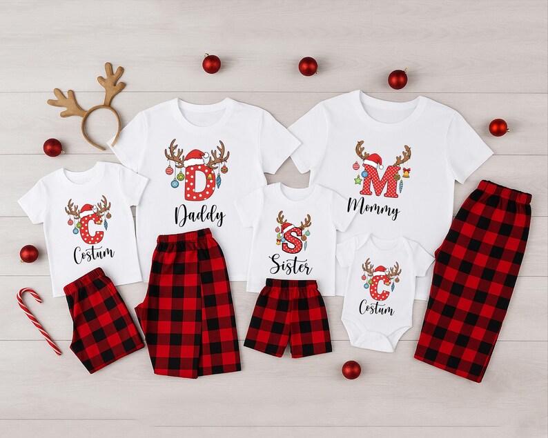 May include: Family Christmas pajamas set with white t-shirts and red and black plaid bottoms. The shirts feature reindeer antlers, Santa hats, and the words "Daddy", "Mommy", "Sister", and "Costum". Includes a reindeer antler headband.
