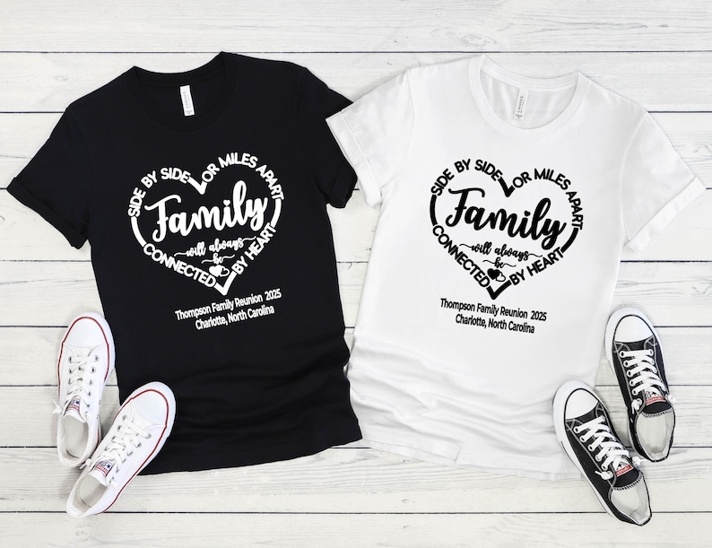 May include: A black t-shirt and a white t-shirt, each featuring a heart-shaped graphic with the text "Side by side or miles apart, Family will always be connected by heart" and "Thompson Family Reunion 2025, Charlotte, North Carolina".