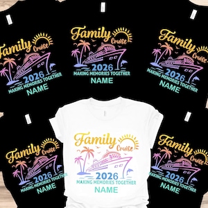 May include: A collection of black and white t-shirts with a colorful graphic design. The design includes the words "Family Cruise 2026" with a cruise ship, palm trees, a dolphin, and the text "Making Memories Together NAME".