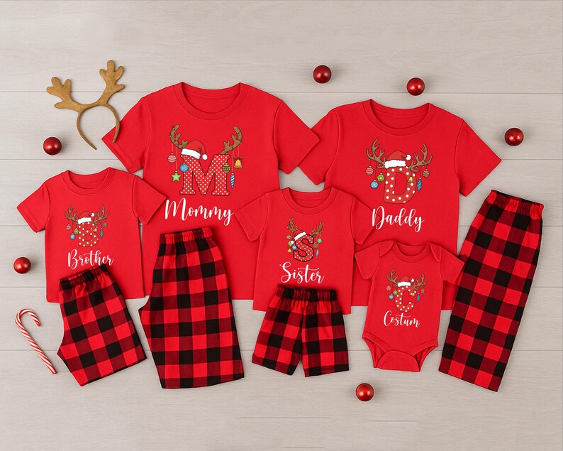 May include: Red Christmas family pajama sets with matching plaid bottoms. Each shirt features a reindeer design with a Santa hat and the words "Mommy", "Daddy", "Brother", "Sister", and "Cousin". Includes a reindeer antler headband and red ornaments.