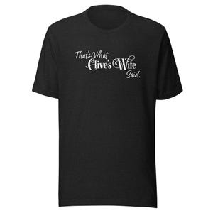 Peut inclure: T-shirt noir avec l'inscription blanche "That's What Clive's Wife Said" en écriture cursive. Le t-shirt a un col rond et des manches courtes. Le tissu semble avoir une texture chinée.