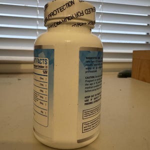 K&ouml;nnte beinhalten: Eine wei&szlig;e Erg&auml;nzungsflasche mit silbernem Etikett und blauen Akzenten. Die Flasche hat einen wei&szlig;en Deckel mit Text. Das Etikett enth&auml;lt Text &uuml;ber die Fakten zu den Nahrungserg&auml;nzungsmitteln und die empfohlene Anwendung. Die Flasche enth&auml;lt 30 Kapseln.