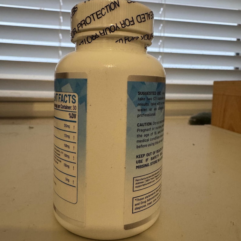 K&ouml;nnte beinhalten: Eine wei&szlig;e Erg&auml;nzungsflasche mit silbernem Etikett und blauen Akzenten. Die Flasche hat einen wei&szlig;en Deckel mit Text. Das Etikett enth&auml;lt Text &uuml;ber die Fakten zu den Nahrungserg&auml;nzungsmitteln und die empfohlene Anwendung. Die Flasche enth&auml;lt 30 Kapseln.