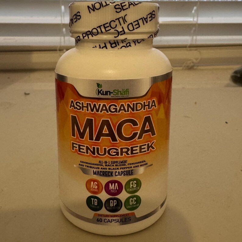 Może przedstawiać: Biała butelka z suplementem z złotą i pomarańczową etykietą. Na etykiecie widnieje napis "Ashwagandha Maca Fenugreek" i tekst "All-in-1 Supplement". Butelka zawiera 60 kapsułek.