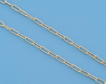 May include: A gold-toned chain necklace featuring elongated, rectangular paperclip-style links. The chain consists of two parallel strands of uniform, polished metal links that are connected in a repeating, symmetrical pattern throughout the length.