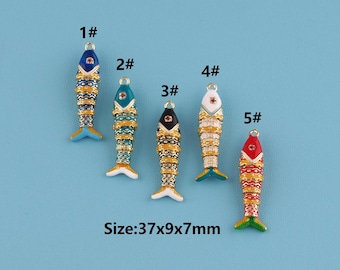 May include: Five colorful fish-shaped charms with intricate designs. Each charm is approximately 1.46 inches long, 0.35 inches wide, and 0.28 inches thick. The charms feature various color combinations, including blue, green, black, white, and red, with gold accents.