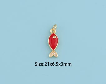 May include: A gold-colored fish charm with a red enamel body and a small clear gem. The fish has a tail with small clear gems. The text on the image reads: Size: 21x6.5x3mm.