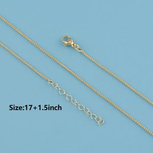 May include: Gold-colored necklace with a delicate chain and adjustable length. The necklace is shown against a light blue background. The text "Size: 17 + 1.5 inch" is visible in the image.