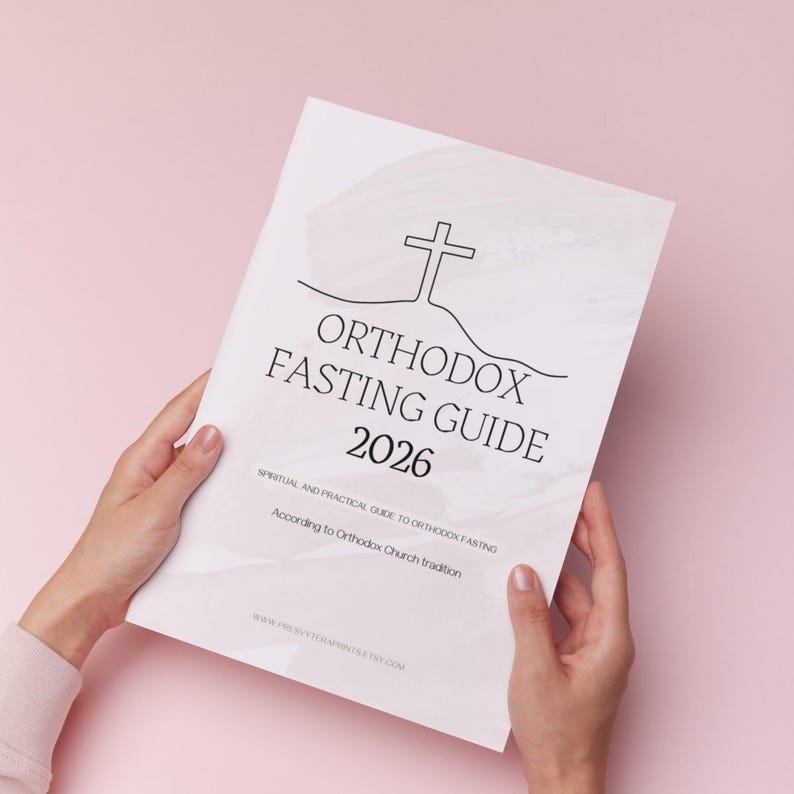 May include: A white Orthodox Fasting Guide 2026 held by hands against a pink background. The cover features a cross design and the text "ORTHODOX FASTING GUIDE 2026". Additional text includes "Spiritual and Practical Guide to Orthodox Fasting" and "According to Orthodox Church tradition."