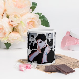 Puede incluir: Taza de cerámica blanca con una ilustración de estilo manga de un hombre con un cuello alto negro y un reloj. El diseño se repite alrededor de la taza. La taza está rodeada de flores, caramelos y chocolate.