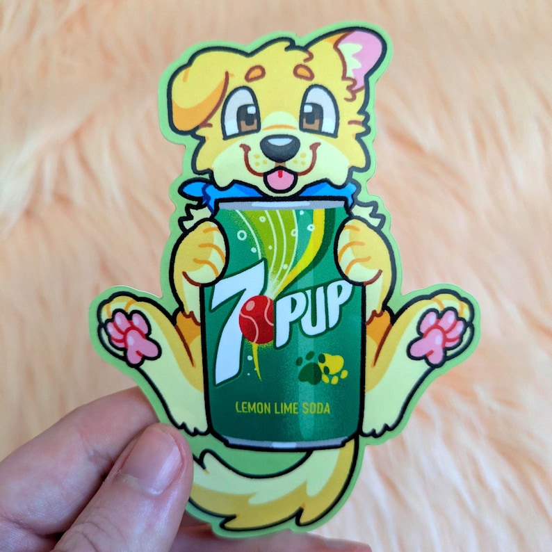 May include: A die-cut sticker featuring a yellow cartoon dog holding a green soda can. The can displays the text 7 PUP, a red ball graphic, and the words LEMON LIME SODA. The dog has pink paw pads and a blue collar, with a light green border outline.