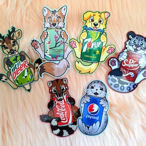May include: Six die-cut stickers featuring cartoon animals holding soda cans. The animals include a deer with Mtn Deer, a fox with AwooZona, a dog with 7Pup, a snow leopard with Dr. Snepper, a coati with Coat-Cola, and a seal with Pepseal.