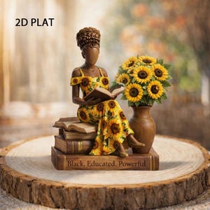 May include: A decorative figurine of a woman in a yellow sunflower print dress, seated on books and reading. A vase of sunflowers sits beside her. The base of the books reads "Black. Educated. Powerful."