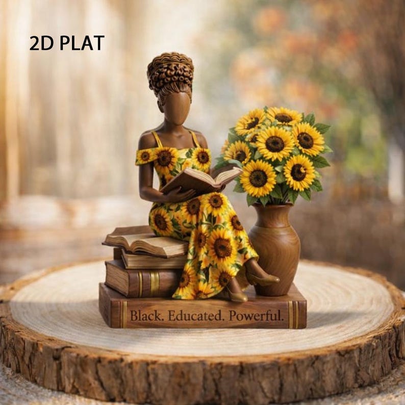 May include: A decorative figurine of a woman in a yellow sunflower print dress, seated on books and reading. A vase of sunflowers sits beside her. The base of the books reads "Black. Educated. Powerful."