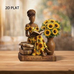 May include: A decorative figurine of a woman in a sunflower-print dress reading a book, seated atop stacked books. A vase of sunflowers sits beside her. The base of the books reads "Black. Educated. Powerful."