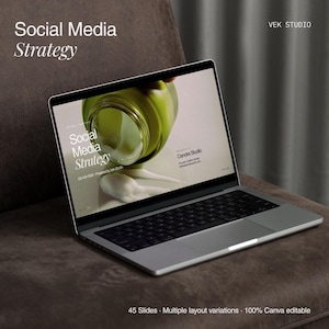 May include: A silver laptop displaying a presentation titled Social Media Strategy on its screen. The screen shows a graphic of a green jar with cream, the text Social Media Strategy, Q3-Q4 2025, Prepared by Vek Studio, and Cendre Studio.