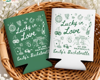 May include: Two can coolers, one green and one white, with the text "Lucky in Love" and various illustrations. The green cooler has white text and graphics, while the white cooler has green text and graphics. Both say "Emily's Bachelorette".