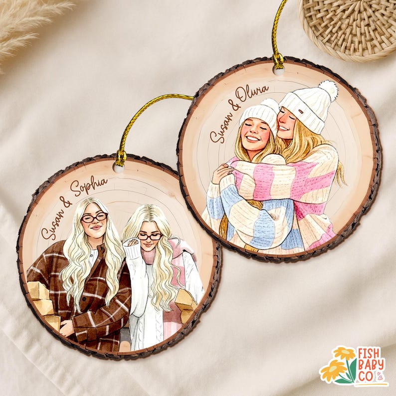May include: Two wooden ornaments with illustrations of women. One shows two women in a plaid jacket and sweater, the other shows two women hugging, wearing hats and sweaters. Each ornament has a gold string for hanging.