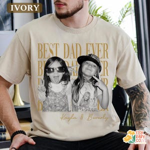 Puede incluir: Camiseta de color marfil con el texto dorado "BEST DAD EVER". Una foto en blanco y negro de dos ni&ntilde;as est&aacute; impresa en la camiseta, con los nombres "Kayla & Beverly" debajo. La camiseta es de estilo casual.
