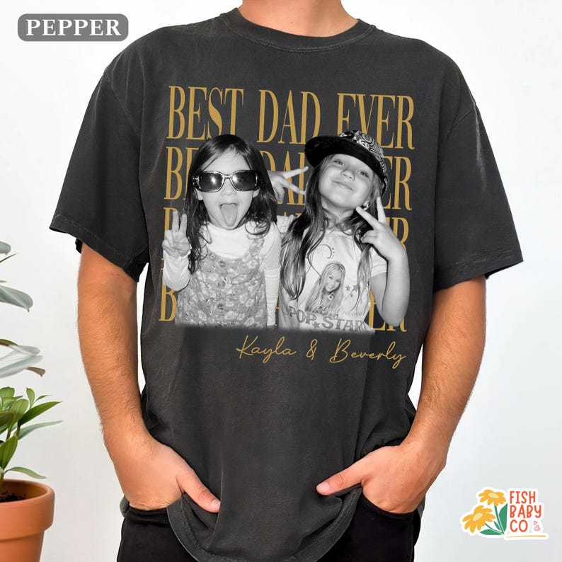 Puede incluir: Camiseta negra con un dise&ntilde;o de texto dorado que dice "BEST DAD EVER" y presenta una foto en blanco y negro de dos ni&ntilde;as. Los nombres "Kayla & Beverly" est&aacute;n impresos debajo de la foto.
