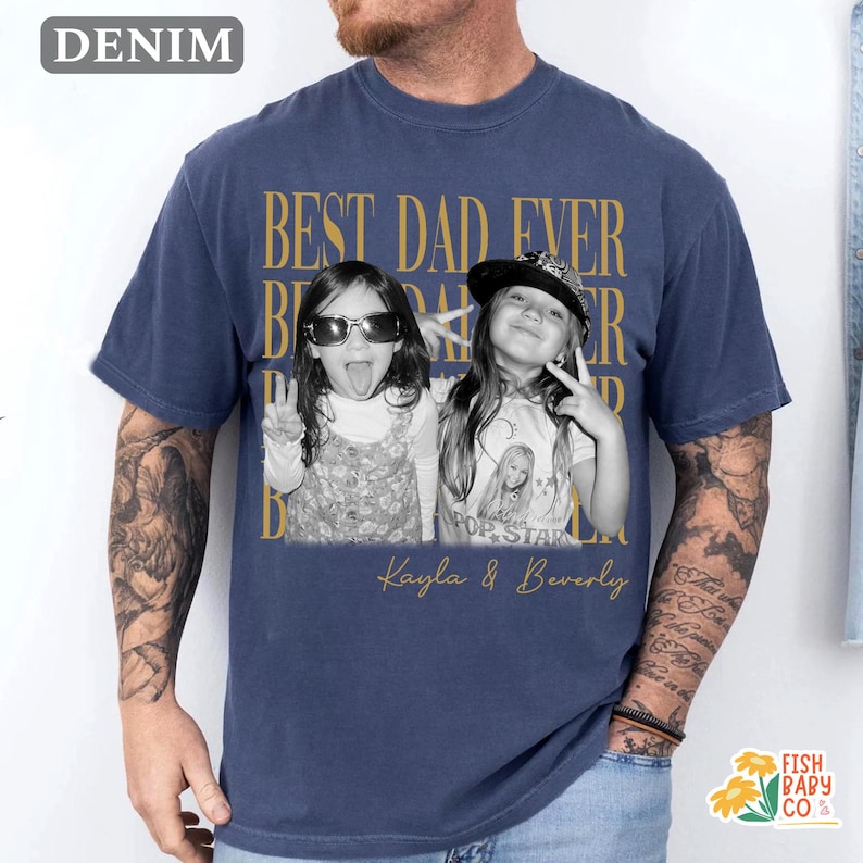 Puede incluir: Camiseta azul marino con la frase dorada "BEST DAD EVER". Presenta una foto en blanco y negro de dos ni&ntilde;as, con los nombres "Kayla & Beverly" impresos debajo.