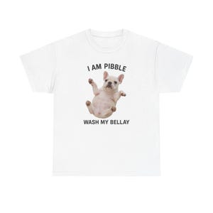 May include: White t-shirt with a French Bulldog graphic. The dog is lying on its back with its paws in the air. Above the dog is the text "I AM PIBBLE" and below the dog is the text "WASH MY BELLAY".