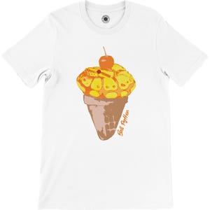 K&ouml;nnte beinhalten: Wei&szlig;es T-Shirt mit einer Grafik einer Eist&uuml;te mit einer Kirsche. Das Eis ist gelb und orange, und die Waffel ist braun. Der Text "Ball Python" ist in Orange geschrieben.