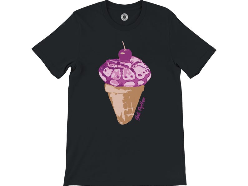 K&ouml;nnte beinhalten: Schwarzes T-Shirt mit einer skurrilen Illustration eines Eiswaffel. Das Eis ist lila mit einer Kirsche, und die Waffel ist hellbraun. Der Text "Ball Python" ist kursiv geschrieben. Ein lustiges und originelles Design.