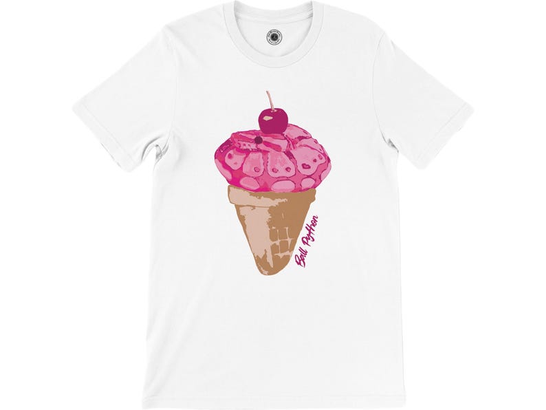K&ouml;nnte beinhalten: Wei&szlig;es T-Shirt mit einer Aquarell-Illustration einer Eist&uuml;te. Das Eis ist rosa mit einer Kirsche, und die T&uuml;te ist braun. Der Text "Ball Python" ist in Rosa geschrieben.