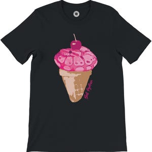 K&ouml;nnte beinhalten: Schwarzes T-Shirt mit einem Design einer rosa Eist&uuml;te und einer Kirsche. Das Eis hat ein einzigartiges Muster, und die Waffel ist hellbraun. Der Text "Ball Python" ist in Rosa auf der Waffel aufgedruckt.
