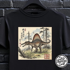 Może przedstawiać: Czarny t-shirt z ilustracją Spinozaura w stylu japońskiego drzeworytu. Grafika zawiera japoński tekst, dinozaura, drzewa i ptaka. Koszulka ma okrągły dekolt i krótkie rękawy.