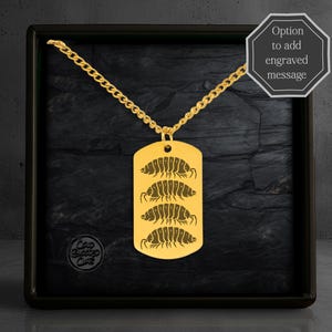 May include: A gold-colored dog tag pendant with a chain. The tag features an engraved design of four pill bugs. The image is set against a dark, textured background within a black frame. Text on the image says "Option to add engraved message."